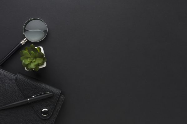 flat-lay-desktop-with-agenda-magnifying-glass